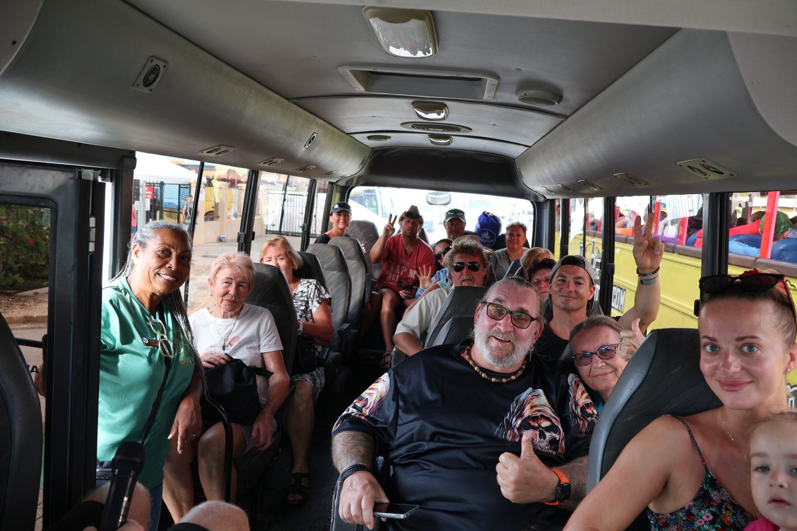 Happy tour group smiling inside the Dushi bus