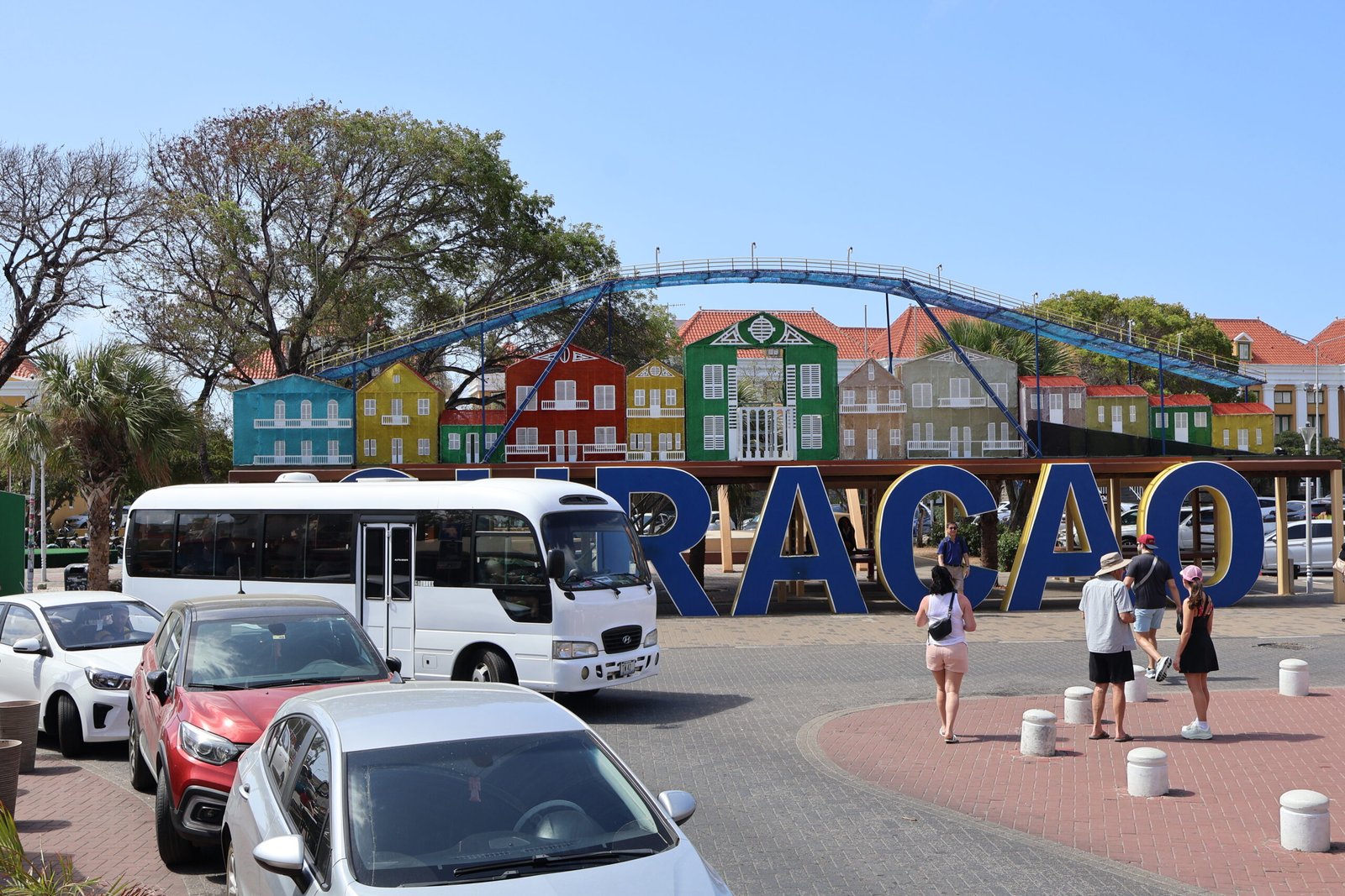 Dushi Experiences bus with colourful Curaçao sign and buildings